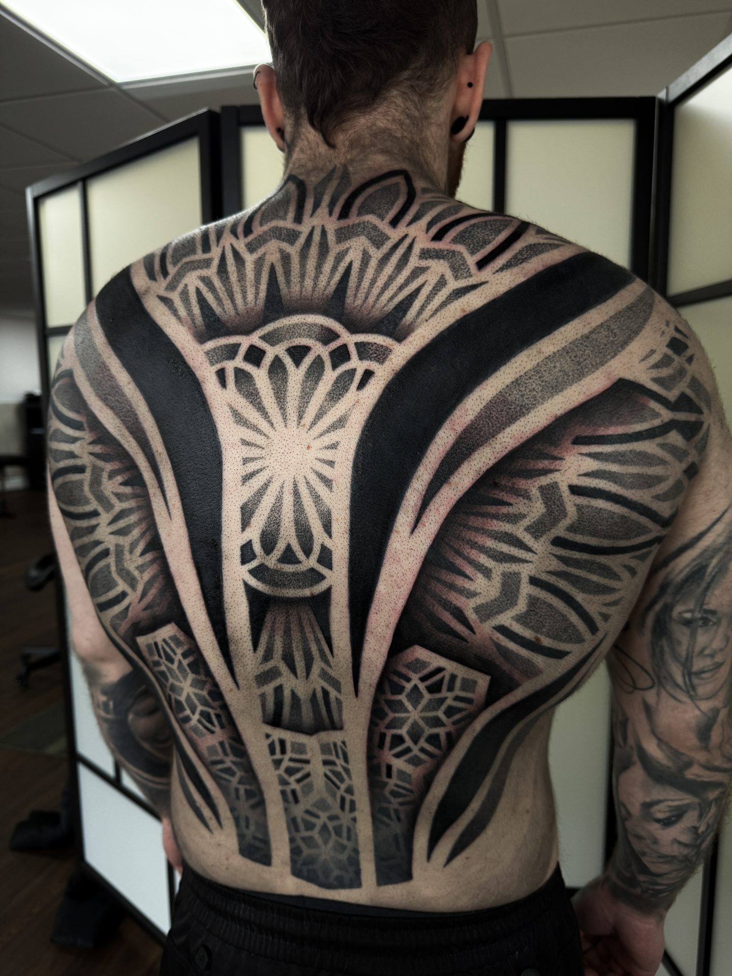 Symmetrical geometric back piece tattoo by Liam Couper