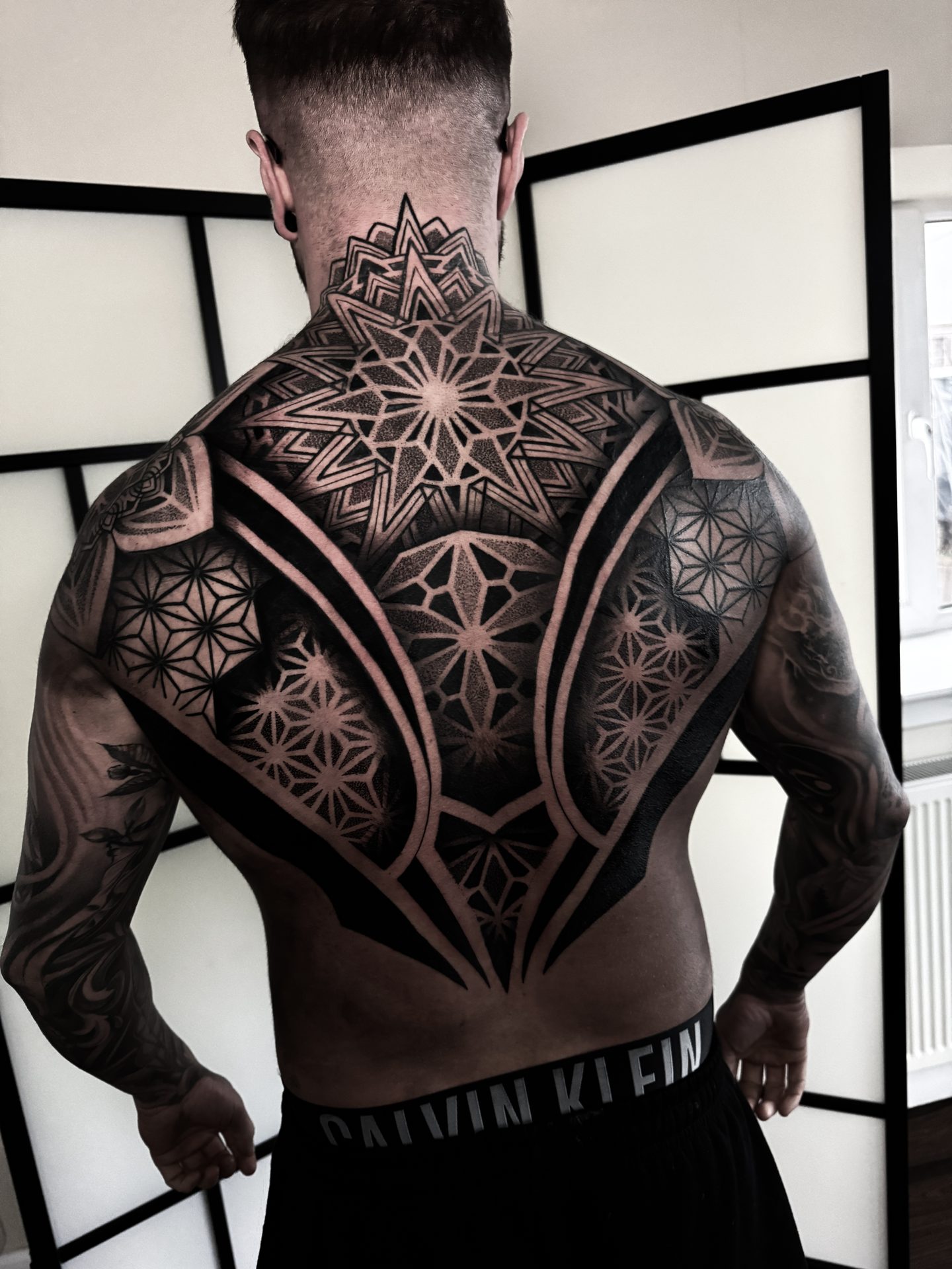 Geometric back and shoulder tattoo by Liam Couper