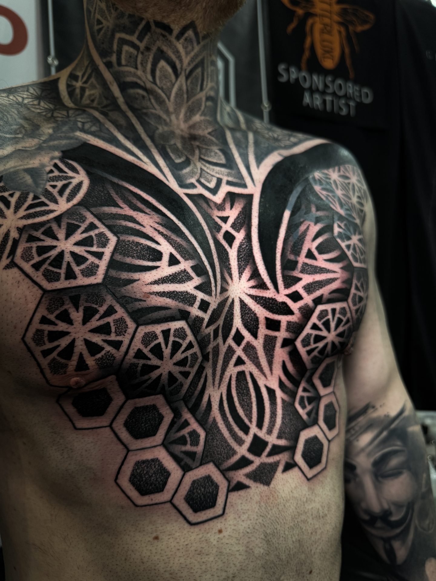 Geometric chest and torso tattoo with skull centrepiece by Liam Couper
