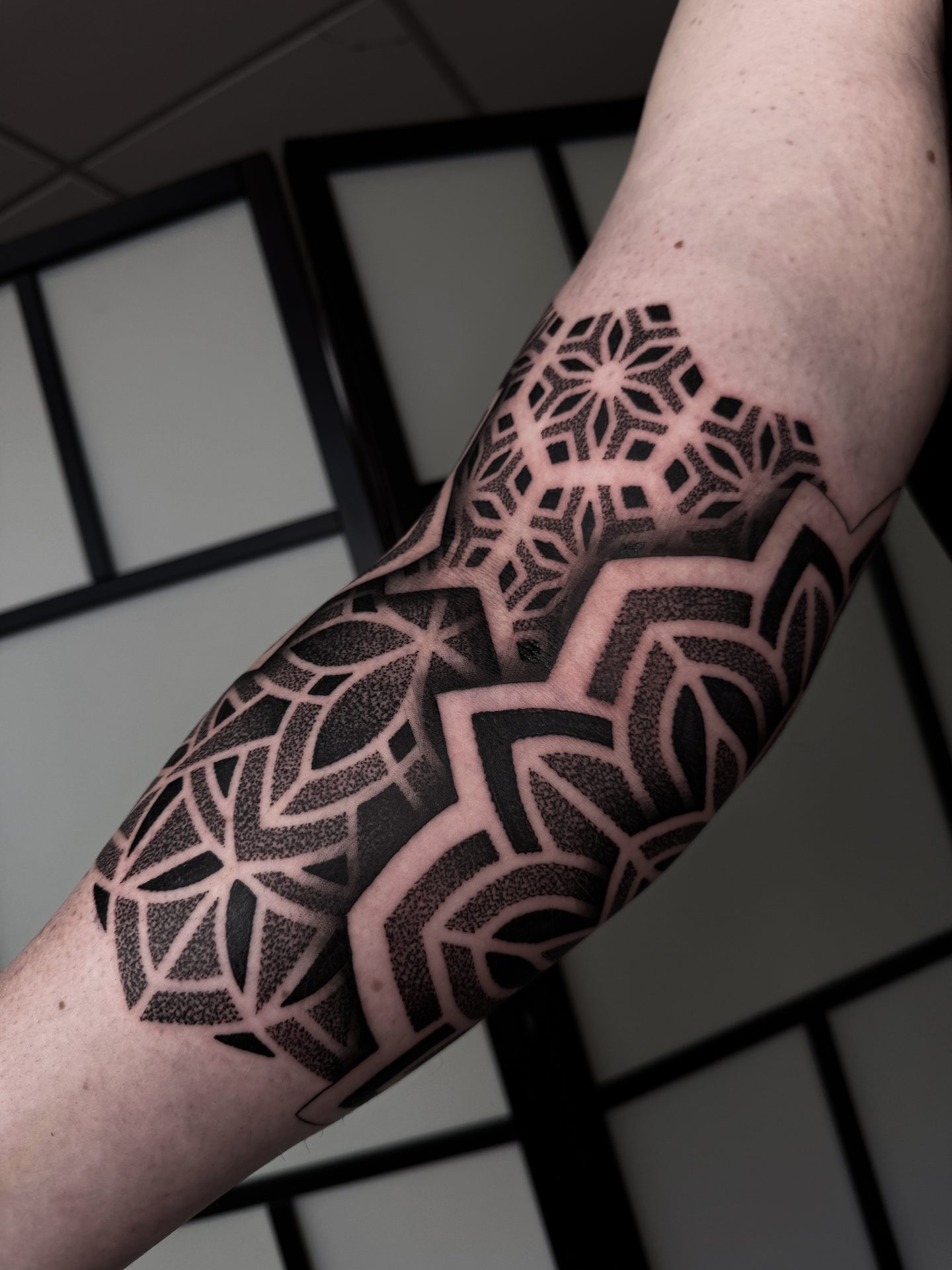 Geometric forearm and elbow tattoo by Liam Couper
