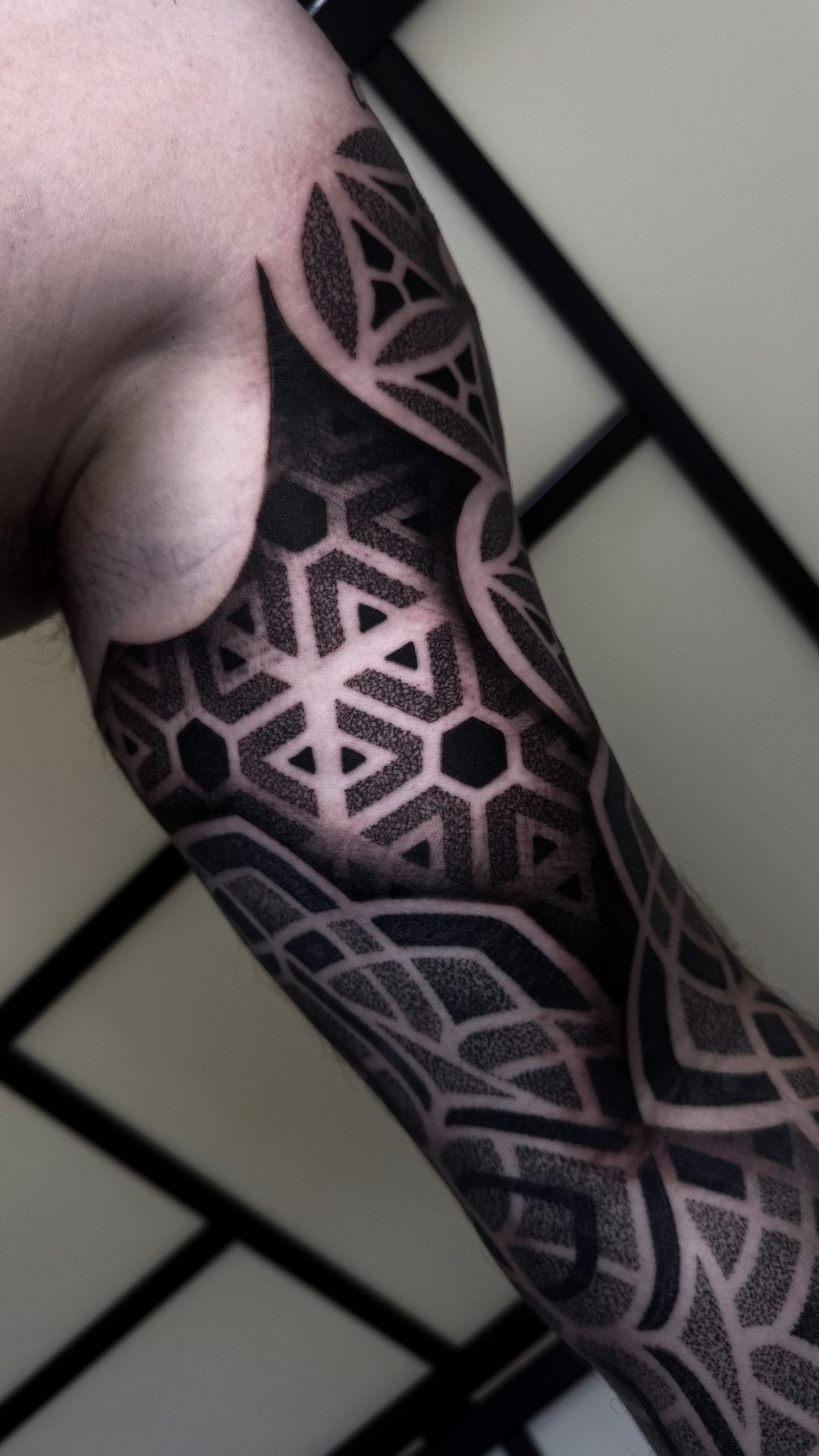 Geometric blackwork half sleeve tattoo by Liam Couper