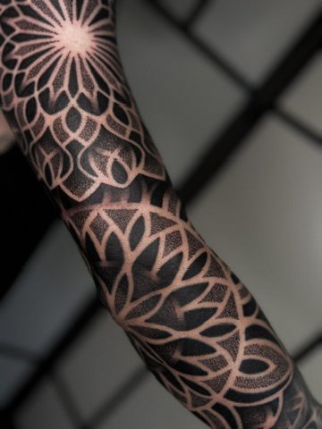 Close up of a geometric dotwork leg sleeve tattoo by Liam Couper