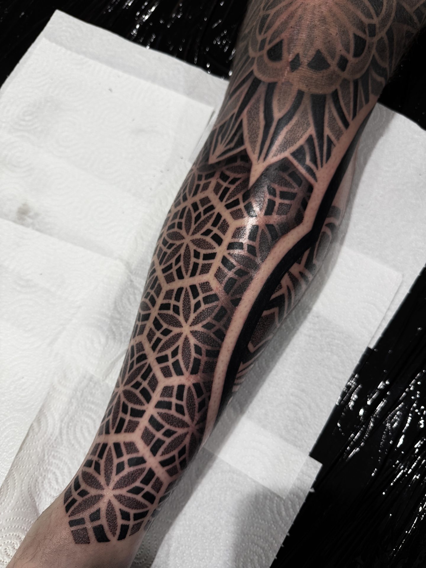 Wrapping geometric leg sleeve tattoo by Liam Couper