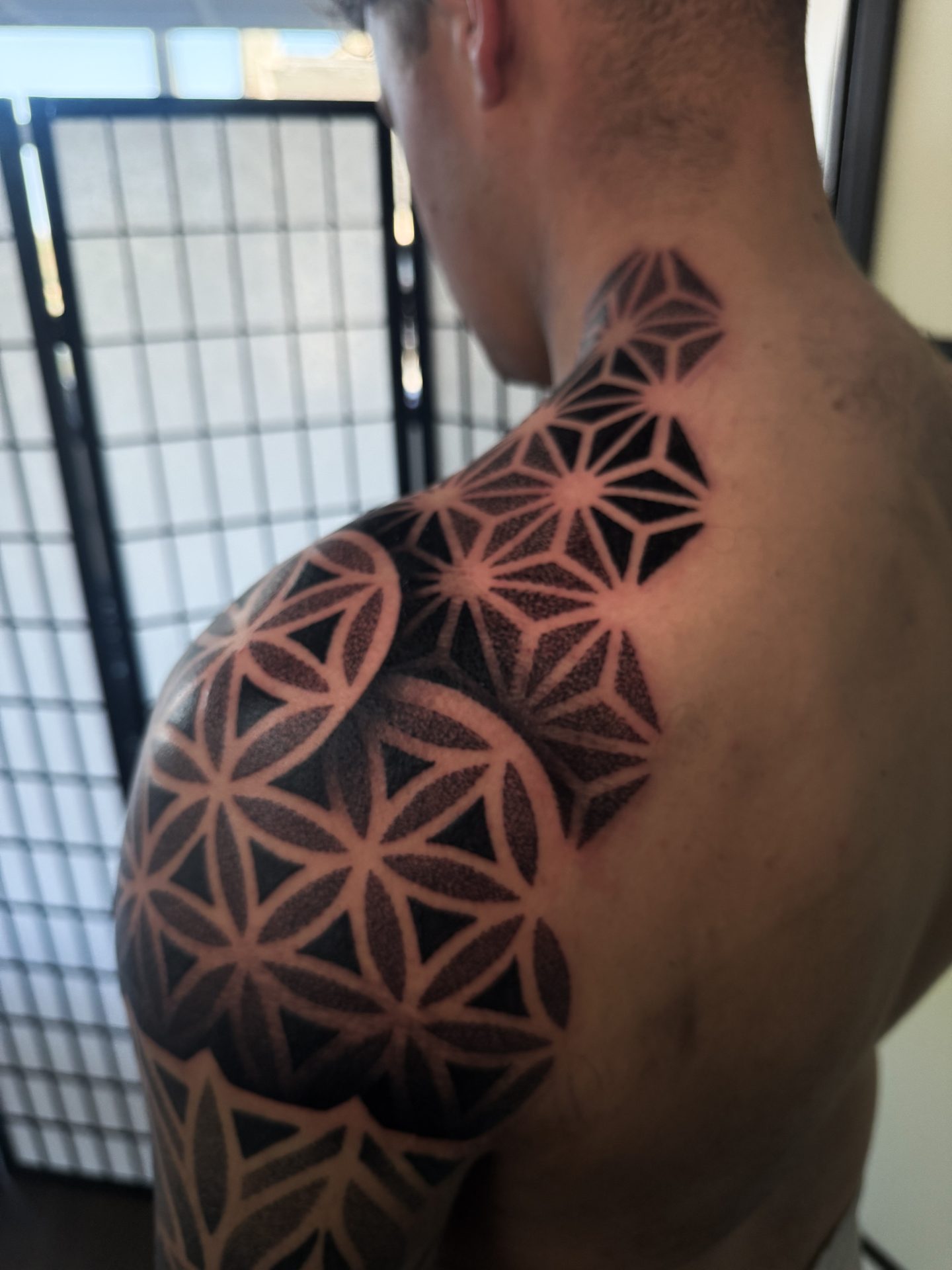 Geometric dotwork shoulder cap tattoo by Liam Couper