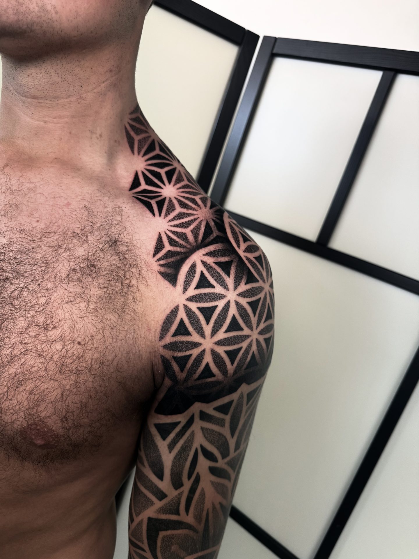Geometric shoulder and chest tattoo by Liam Couper, Fife