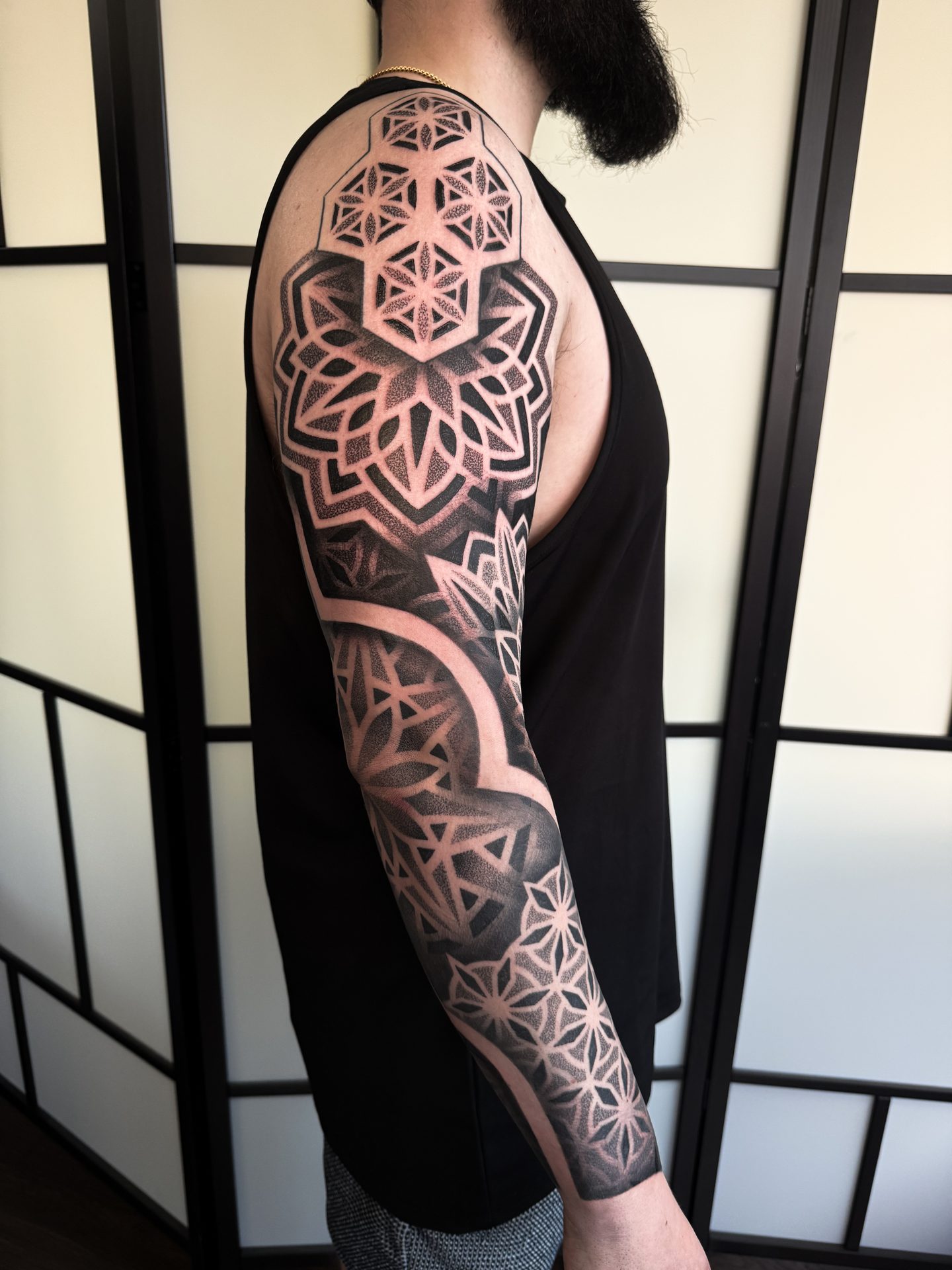 Geometric shoulder and sleeve tattoo by Liam Couper