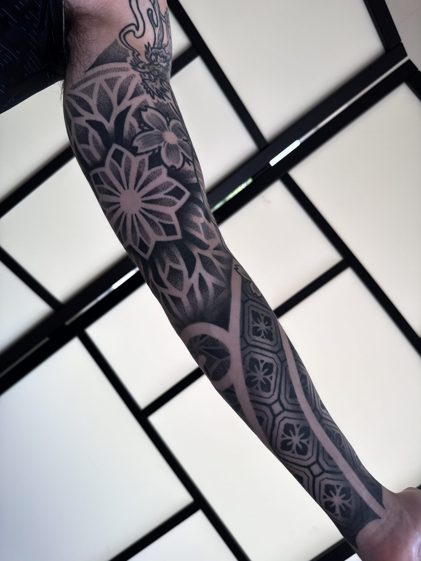 Geometric sleeve tattoo with raised arm by Liam Couper