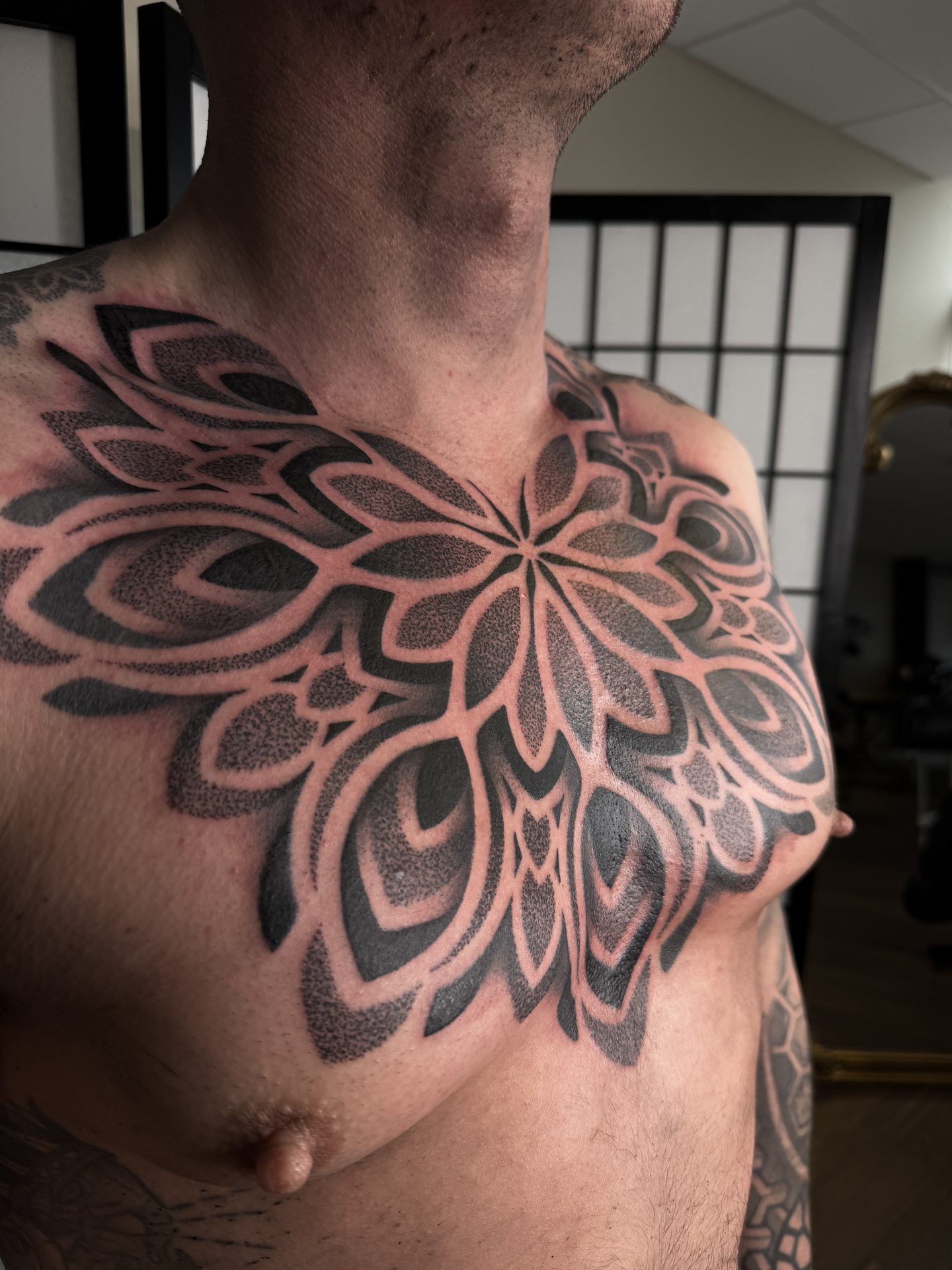 Front view of a mandala chest tattoo by Liam Couper