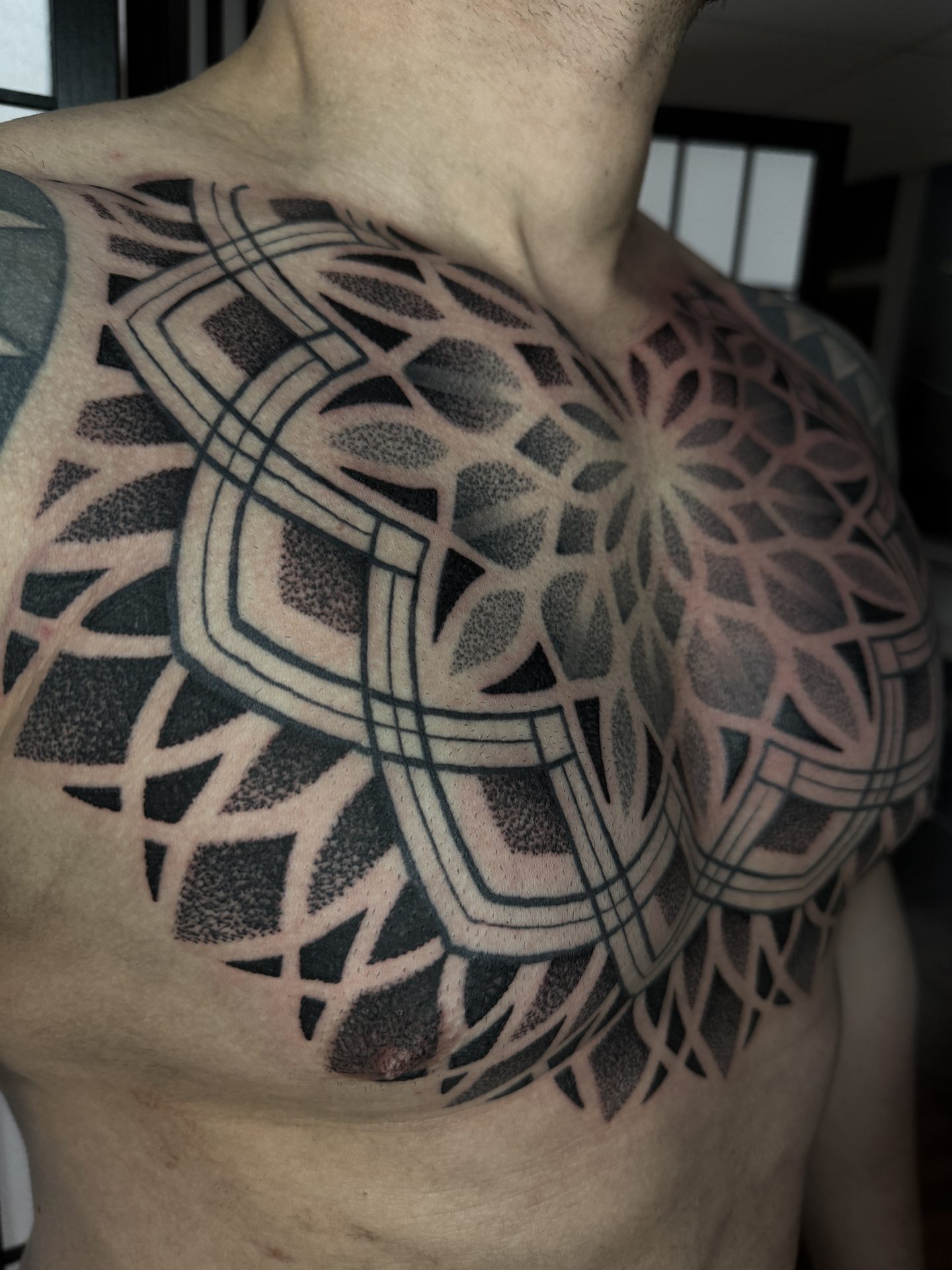 Ornamental mandala chest tattoo by Liam Couper